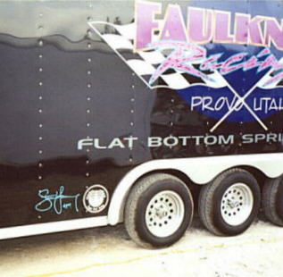 side of a boat trailer with his signature painted on it.